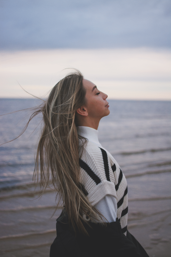 Woman breathing in deeply at the beach