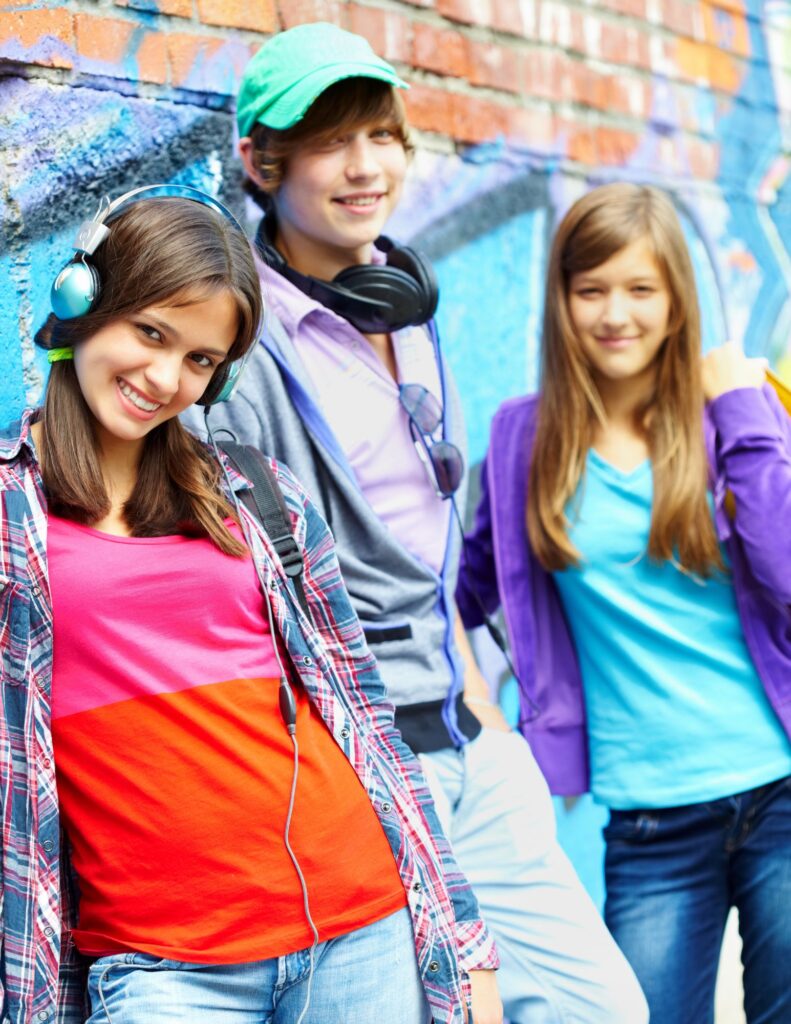 Three teenage kids standing in a group.